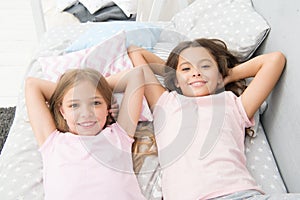 Being as happy as the day is long. Happy little girls having afternoon nap in bedroom. Adorable small children relaxing