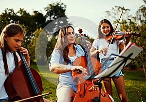 Being a band is great, being a family is better. a beautiful mother playing instruments with her adorable daughters