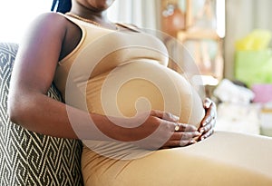 Being this big I need to sit down. a mother to be caressing her baby bump.
