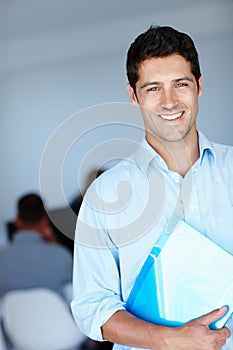 Being in business never felt this good. A shot of a smiling young man holding a document at work.