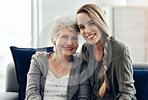 Being deeply loved by someone gives you strength. a senior woman and her adult daughter sitting together at home.