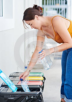 Being environmentally conscious is important to me. Shot of an attractive young woman standing down and putting plastic