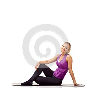 Being fit makes her feel good. A beautiful young woman smiling at you after a workout -isolated.