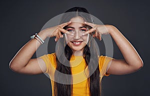 Being normal is boring. Cropped portrait of an attractive teenage girl standing alone and feeling playful against a dark