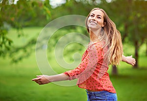 Being in the outdoors makes her feel alive. Shot of a carefree young woman enjoying the outdoors.