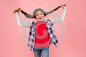 Being such a good girl. Pigtailed little girl pink background. Happy girl hold long hair. Small girl smile in casual