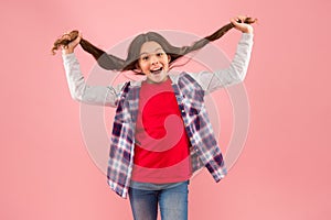 Being such a good girl. Pigtailed little girl pink background. Happy girl hold long hair. Small girl smile in casual photo