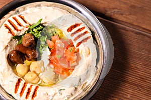 beiruti hummus with chickpeas and tomato served in dish isolated on background top of arabic food cold mezza photo