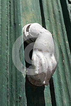 Beja, Alentejo, Portugal. Detail of a wooden door. Each gate knocker has the shape of a hand