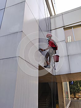 Bekasi, Indonesia, August, 11, 2021 : Workers are cleaning a building at a height