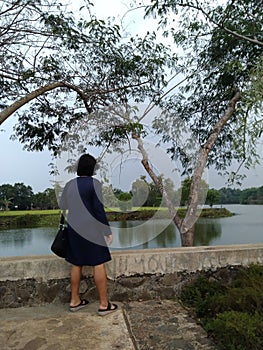Bekasi, Indonesia, July 30, 2021: Asian woman, mirror back at the lake in the Grand Residence of Bekasi