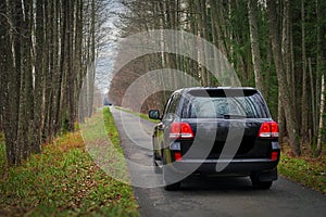 Belarus, Belovezhskaya Pushcha, November 05, 2021 - a Toyota Land Cruiser jeep rides along the road in the autumn forest