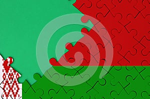 Belarus flag is depicted on a completed jigsaw puzzle with free green copy space on the left side