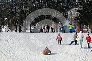Parents and children ride from the snow slides in winter have fun resting in nature.