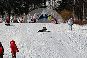 Parents and children ride from the snow slides in winter have fun resting in nature.