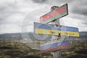 Belarus ukraine russia flag on wooden signpost outdoors in nature.