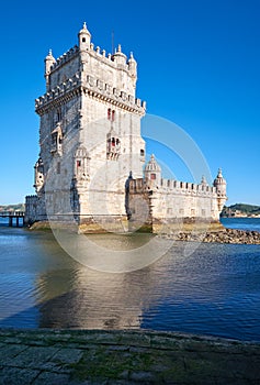 Belem Tower on river Tagus in Lisbon with reflection in water on blue sky background, Portugal