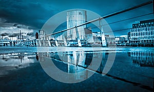 Belfast architecture along River Lagan reflected in a puddle