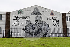 Gunmen mural with texts on a building facade in Belfast, United Kingdom