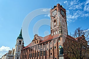 The belfry of the baroque church, the turret of the gothic town hall and the statue of Copernicus in the city of Torun
