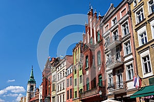 The belfry of a church and facades of historic tenement houses in Torun