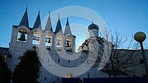 The belfry of the Tikhvin monastery. The sun`s rays