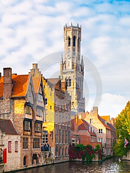 Belfry Tower and brick houses at water canal, Bruges, Belgium. HDR image