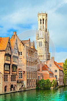 Belfry tower and old traditional houses along the canal in Bruges, Belgium.