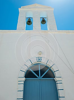 Belfry with two bells small whitewashed chapel Kimolos island Cyclades Greece. Vertical photo