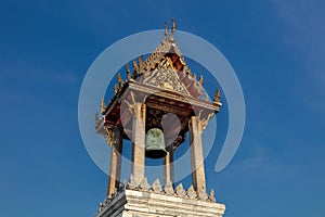 Belfry, Wat Benchamabophit, Thailand. Single bell, golden decoration blue sky in background.