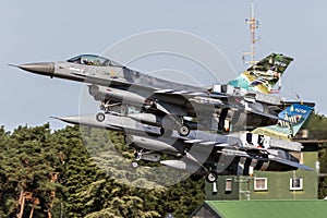 Belgian Air Force F-16 fighter jets in special colors with D-Day invasion stripes taking off from Kleine-Brogel Airbase