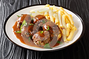 Belgian Boulets sauce lapin meatballs in apple gravy and French fries closeup in the plate. Horizontal