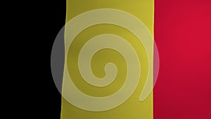 The Belgian flag flutters in the wind. Symbol of statehood and sovereignty of the country. Testura fabric on the panel