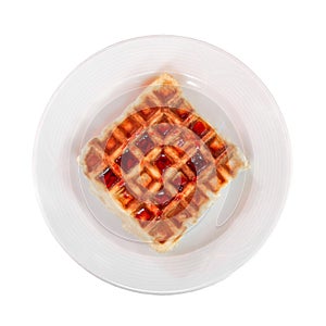Belgian waffle with cherry jam on plate, top view, isolated on white background with clipping path