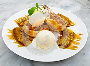 Belgian waffle with ice cream and grilled banana topped with honey.