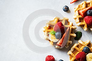 Belgian waffles with berries on a gray background. Top view and copy space