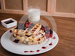 Belgian waffles with berries. milk. Syrup. Wooden table.