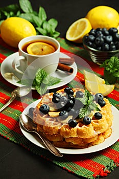 Belgian waffles with blueberry and a cup of tea with lemon