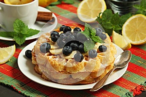 Belgian waffles with blueberry and a cup of tea with lemon