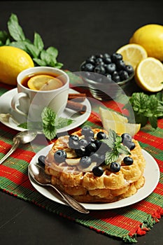Belgian waffles with blueberry and a cup of tea with lemon