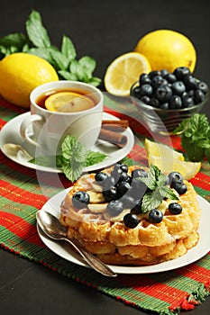 Belgian waffles with blueberry and a cup of tea with lemon