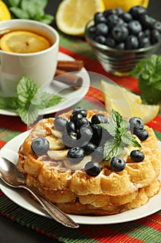 Belgian waffles with blueberry and a cup of tea with lemon