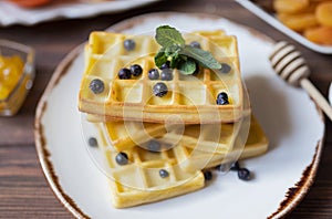 Belgian waffles for breakfast with honey and currants