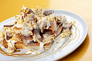 Belgian waffles with caramel topping, chocolate bars and popcorn