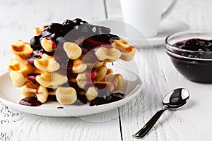 Belgian waffles with creem and berrie jam on white wooden background