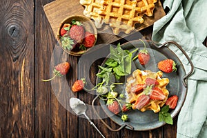 Belgian waffles with fresh berrie strawberries and ricotta cheese for breakfast on a rustic table. View from above. Copy space