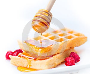 Belgian waffles with honey and berries closeup