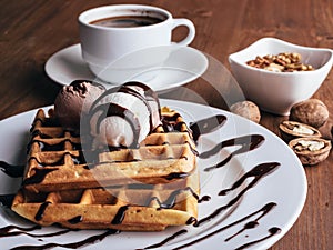 Belgian waffles with ice cream. Chocolate and nuts. wooden table. Rustik