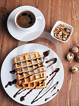 Belgian waffles with ice cream. Chocolate and nuts. wooden table. Rustik