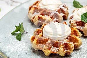 Belgian waffles with icing sugar and Whipped Cream. Culinary, cooking, bakery concept. Food recipe background. Close up